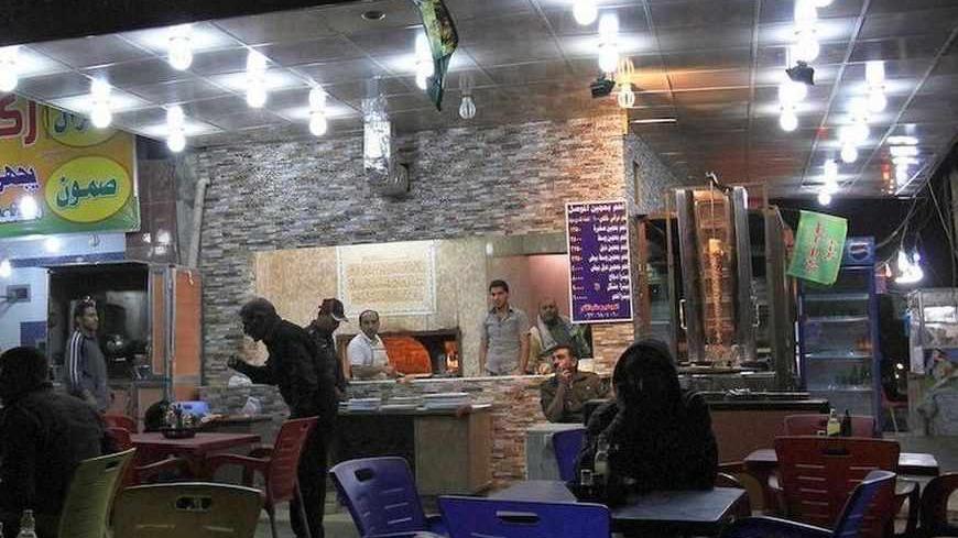 People sit outside a cafe in Baghdad December 1, 2011. The last 13,000 U.S. troops will pull out of Iraq by the end of the year. Violence in the country has dropped sharply since the heights of sectarian slaughter in 2006-2007, but at least 10 people were killed in a bombing just north of the capital Baghdad.   REUTERS/Shannon Stapleton   (IRAQ - Tags: MILITARY CONFLICT SOCIETY) - RTR2UPPL