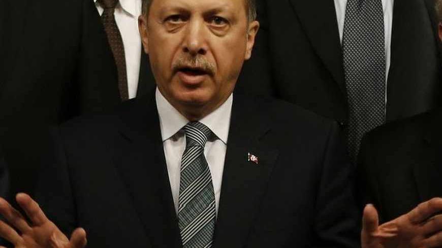 Turkey's Prime Minister Tayyip Erdogan (C) reacts as he poses with his Greek counterpart Antonis Samaras (L) and Greece's Foreign Minister Dimitris Avramopoulos (R) after signing agreements in Istanbul March 4, 2013. REUTERS/Murad Sezer (TURKEY - Tags: POLITICS) - RTR3EK7W