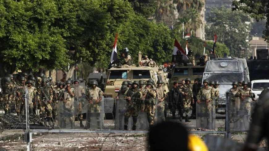 Army soldiers stand guard near the Republican Guard headquarters after clashes with supporters of deposed Egyptian president Mohamed Mursi, in Cairo, July 8, 2013. The death toll in violence on Monday at the Cairo headquarters of the Republican Guard rose to 42, Egyptian state television said, after the Muslim Brotherhood accused the security forces of attacking protesters there. REUTERS/ Asmaa Waguih (EGYPT - Tags: POLITICS CIVIL UNREST) - RTX11GJ0