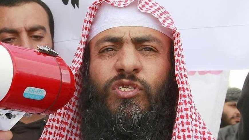 Jordanian Salafi jihadi leader Abu Sayyaf (R) speaks to his supporters and the media during a demonstration against prolonged detention of the group's leaders near the prime minister's office in Amman, April 9, 2013. REUTERS/Muhammad Hamed (JORDAN - Tags: POLITICS CIVIL UNREST RELIGION) - RTXYES1