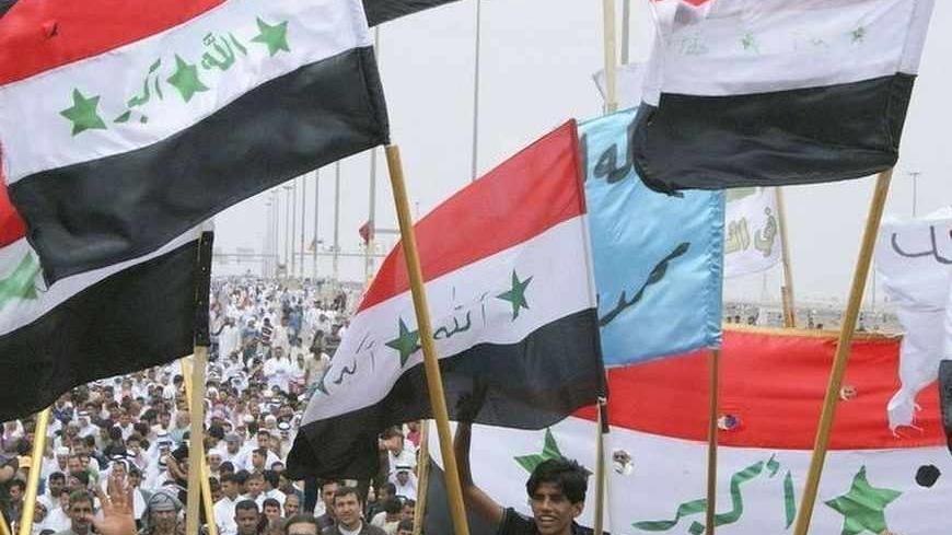 Iraqi Sunni Muslims wave the old flags of Iraq during an anti-government demonstration in Falluja, 50 km (31 miles) west of Baghdad May 3, 2013.  Tens of thousands of Sunni Muslims poured onto the streets of Ramadi and Falluja in the western province of Anbar following Friday prayers, in their biggest show of strength since the outbreak of protests last year. REUTERS/Mohanned Faisal (IRAQ - Tags: POLITICS RELIGION CIVIL UNREST) - RTXZ987