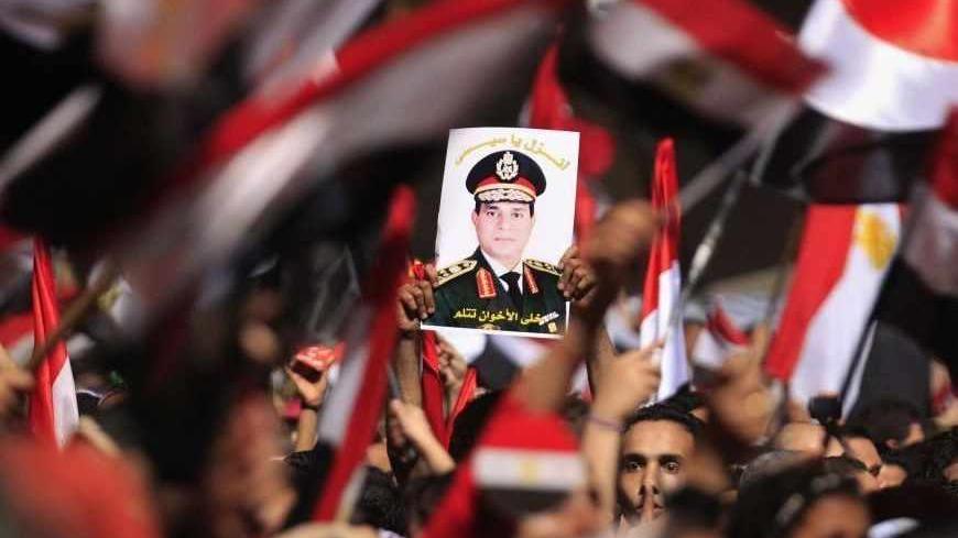 Protesters, who are against Egyptian President Mohamed Mursi, hold a poster featuring the head of Egypt's armed forces General Abdel Fattah al-Sisi in Tahrir Square in Cairo July 3, 2013. Egypt's armed forces overthrew elected Islamist President Mohamed Mursi on Wednesday and announced a political transition with the support of a wide range of political, religious and youth leaders. A statement published in Mursi's name on his official Facebook page after al-Sisi's speech said the measures announced amounte