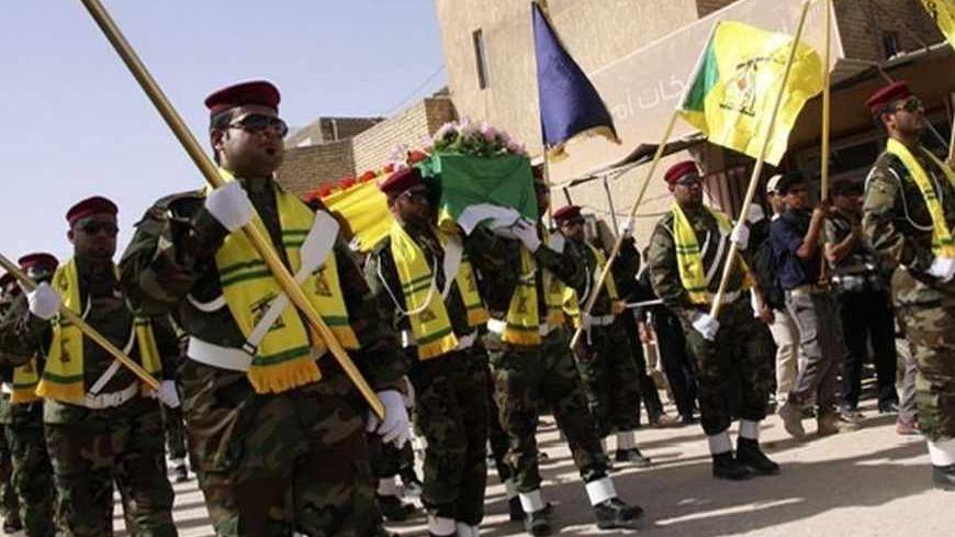Members of Hezbollah Iraq carry the coffin of their comrade Reza Khudair al-Khalidi, who was also a Shi'ite fighter and killed in clashes with the Free Syrian Army, during his funeral in Kerbala, 110 km (70 miles) south of Baghdad, June 5, 2013. Hundreds of Iraqis attended the funeral on Thursday, and relatives of Khalidi said he was killed while fighting on the outskirts of the border town of Qusair. REUTERS/Mushtaq Muhammed (IRAQ - Tags: CONFLICT CIVIL UNREST MILITARY) - RTX10CYT