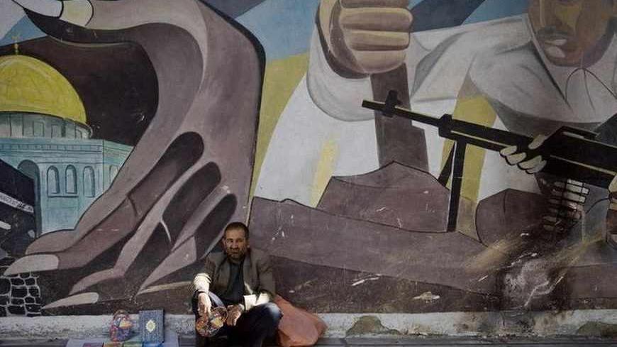 EDITORS' NOTE: Reuters and other foreign media are subject to Iranian restrictions on their ability to film or take pictures in Tehran.

A vendor sits under an anti-Israel mural during a demonstration after Friday prayers in Tehran October 9, 2009. REUTERS/Morteza Nikoubazl (IRAN POLITICS RELIGION) - RTXPGS2