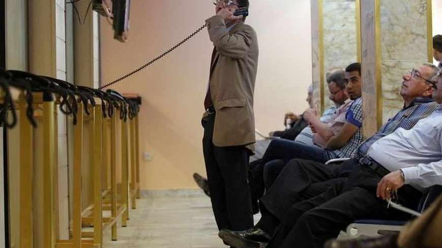 An investor speaks on the phone during trading hours at the Iraq Stock Exchange (ISX) in Baghdad, April 2, 2013. Last month's scene at the headquarters of the Baghdad bourse revealed the struggle which Iraq faces to modernise its financial system: it must overcome primitive, ultra-conservative savings habits born of decades of war and political instability. Picture taken April 2, 2013. REUTERS/Mohammed Ameen (IRAQ - Tags: BUSINESS) - RTXY6UX