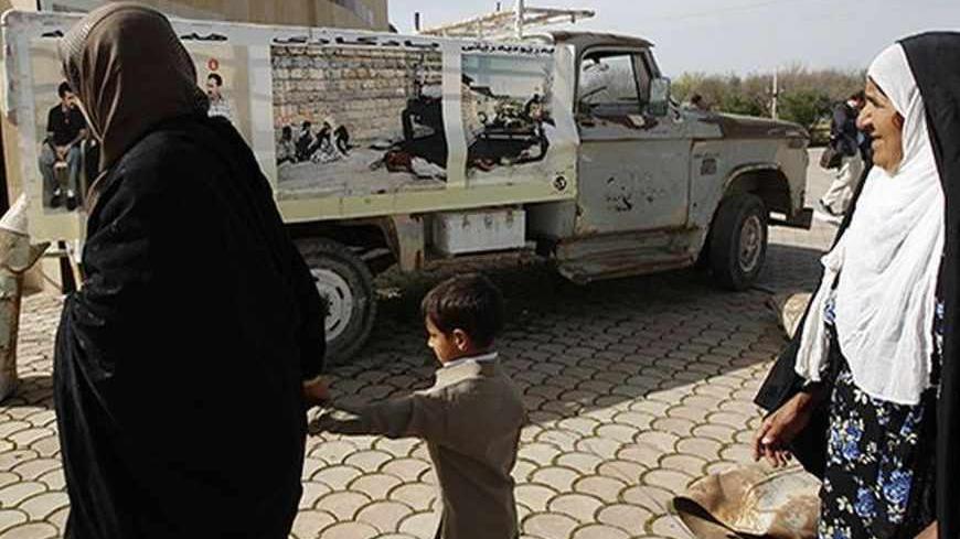 Kurdish women walk past a truck that was hit in the 1988 chemical attack at the memorial site for victims of the attack in the Kurdish town of Halabja, near Sulaimaniya, 260 km (160 miles) northeast of Baghdad, March 16, 2013. Iraqi Kurds on Saturday marked the 25th anniversary of the chemical attack on the northern Iraqi city of Halabja by Saddam Hussein's forces. Up to 5,000 people may have been killed by chemical gas, villages were razed and thousands of Kurds were forced into camps during the 1988 Anfal