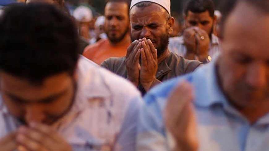 A supporter of former Egyptian President Mohamed Mursi performs prayers near Cairo University in Cairo July 4, 2013. The leader of the Muslim Brotherhood was arrested by Egyptian security forces on Thursday in a crackdown against the Islamist movement after the army ousted the country's first democratically elected president Mursi. At least 16 people have been killed and hundreds wounded in street clashes across Egypt since Mursi's overthrow. REUTERS/Suhaib Salem (EGYPT - Tags: POLITICS CIVIL UNREST) - RTX1