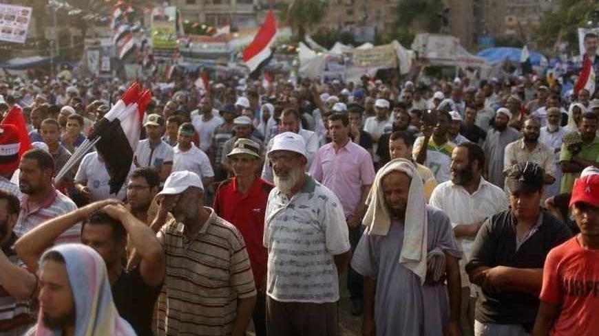 Supporters of deposed President Mohamed Mursi listen to a speech during a rally around the Raba El-Adwyia mosque square in Cairo July 24, 2013. Egypt's military chief called for mass rallies on Friday to give him a mandate to tackle violence that has surged following the overthrow of Islamist President Mohamed Mursi, ramping up pressure on the Muslim Brotherhood. Underscoring the potential for trouble, Mursi's backers announced plans for 34 marches in and around Cairo on Friday.  REUTERS/Asmaa Waguih  (EGYP