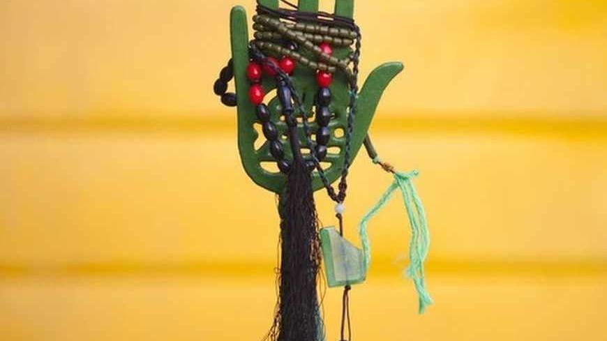 Prayer beads are tied up on a religious symbol near a holy shrine during the month of Ramadan in northern Tehran August 4, 2011. REUTERS/Morteza Nikoubazl (IRAN - Tags: RELIGION SOCIETY) - RTR2PMGN