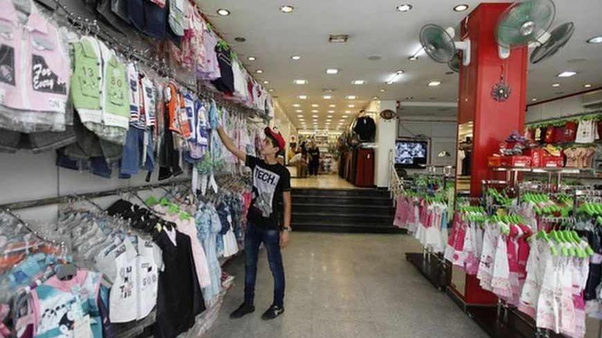 A customer shops for clothes at a clothing store in Baghdad's Karrada district August 14, 2012. Iraq relies on imports from neighbours like Syria, Turkey and Iran for 95 percent of its consumer goods. Syria in particular is a key supplier of manufactured goods, fresh vegetables and fruit. But as an uprising there against President Bashar al-Assad grinds through its 17th month, the supply of Syrian goods to Iraq is slowly drying up as Syrian businesses are forced to close and trucks struggle to cross borders