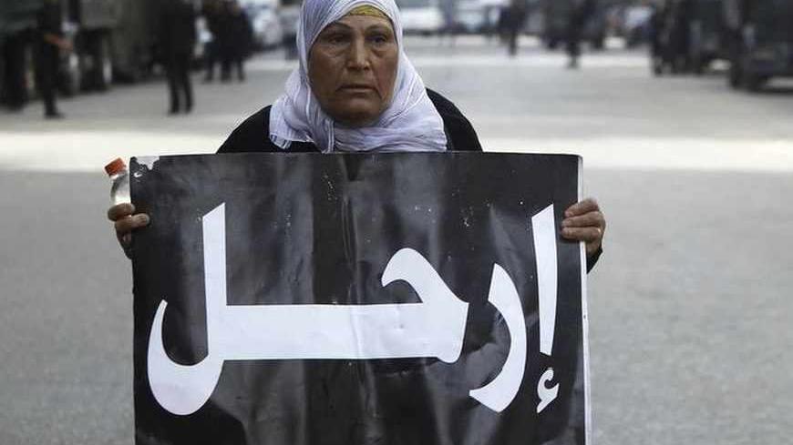 A protester opposing Egyptian President Mohamed Mursi holds a sign reading "Depart" near riot police during a protest against the new judicial law in front of Egypt's Shura Council in Cairo May 25, 2013. Egypt's highest court ruled on Saturday that parts of a revised election law setting out terms for a parliamentary election were unconstitutional, casting fresh doubt over a poll that has already been delayed. The Shura Council has approved, Saturday, the referral of the contentious amendment proposal of th