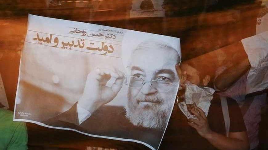 A supporter carries a campaign poster for Iranian presidential candidate Hassan Rohani on the streets of Tehran June 12, 2013. Picture taken June 12, 2013. REUTERS/ISNA/Mehdi Ghassemi (IRAN - Tags: POLITICS ELECTIONS) ATTENTION EDITORS - THIS IMAGE WAS PROVIDED BY A THIRD PARTY. FOR EDITORIAL USE ONLY. NOT FOR SALE FOR MARKETING OR ADVERTISING CAMPAIGNS. THIS PICTURE IS DISTRIBUTED EXACTLY AS RECEIVED BY REUTERS, AS A SERVICE TO CLIENTS - RTX10M6A