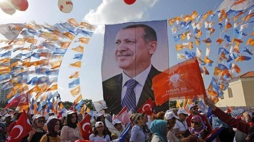 Supporters hold a poster of Turkish Prime Minister Tayyip Erdogan during a rally of ruling AK party in Istanbul June 16, 2013. Tens of thousands of Erdogan's supporters massed at a rally in Istanbul on Sunday, as riot police fired tear gas to break up pockets of anti-government protesters in the city center several kilometers away. REUTERS/Murad Sezer (TURKEY  - Tags: POLITICS CIVIL UNREST)   - RTX10PUP