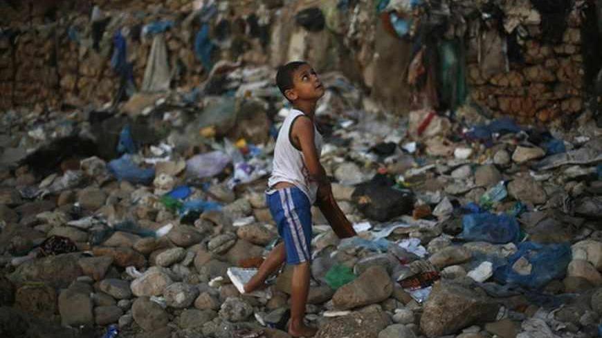 A Palestinian boy looks up as he walks on the beach of Gaza City June 24, 2013. REUTERS/Mohammed Salem (GAZA - Tags: SOCIETY) - RTX10ZFV