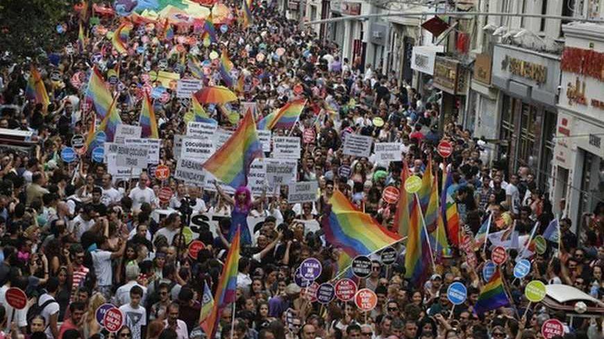 People march during a gay pride parade in central Istanbul June 30, 2013. Tens of thousands of anti-government protesters teamed up with a planned gay pride march in Istanbul. Crowds were stopped by riot police from entering Taksim, the centre of previous protests, but the atmosphere appeared peaceful. REUTERS/Umit Bektas (TURKEY - Tags: POLITICS CIVIL UNREST SOCIETY) - RTX1179R