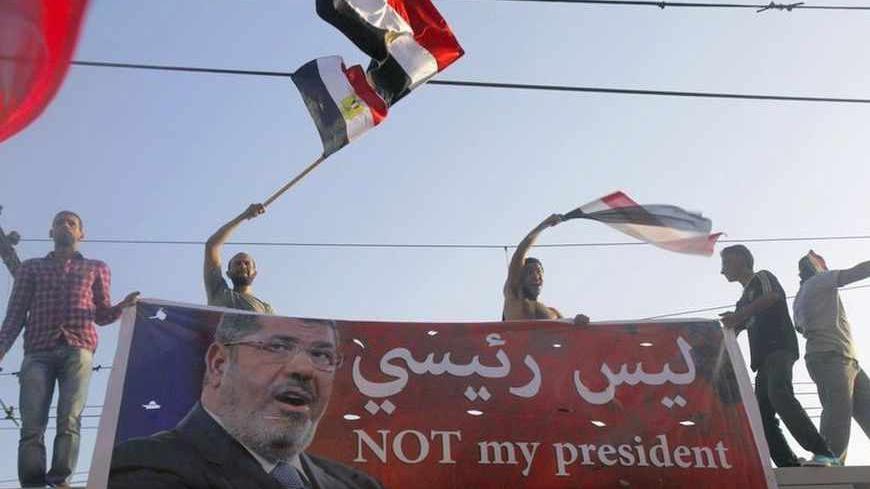 Protesters opposing Egyptian President Mohamed Mursi wave Egyptian flags and shout slogans against him and members of the Muslim Brotherhood, during a protest in front of El-Thadiya presidential palace in Cairo June 30, 2013. Millions of Egyptians flooded into the streets on the first anniversary of Islamist President Mursi's inauguration on Sunday to demand that he resign in the biggest challenge so far to rule by his Muslim Brotherhood.  REUTERS/Amr Abdallah Dalsh  (EGYPT - Tags: POLITICS CIVIL UNREST) - 