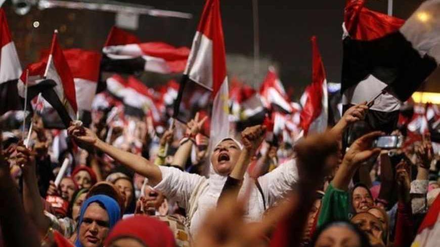 Protesters, who are against Egyptian President Mohamed Mursi, react in Tahrir Square in Cairo July 3, 2013. The head of Egypt's armed forces General Abdel Fattah al-Sisi issued a declaration on Wednesday suspending the constitution and appointing the head of the constitutional court as interim head of state, effectively declared the removal of elected Islamist President Mohamed Mursi. REUTERS/Suhaib Salem (EGYPT - Tags: POLITICS CIVIL UNREST TPX IMAGES OF THE DAY) - RTX11BNS