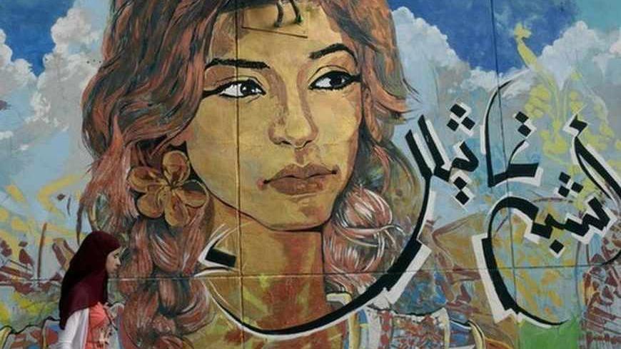 A girl walks past graffiti on a wall near Tahrir square in Cairo July 21, 2013. Egyptian rappers and graffiti artists who captured the spirit of the youthful rebellion that toppled president Hosni Mubarak are toning down their outrage as the path to democracy has become more complicated. Three weeks since the military ousted Mubarak's elected successor, the Islamist Mohamed Mursi, street artists who want neither religious nor military rule see little place in today's exhausted Egypt for their once defiant w