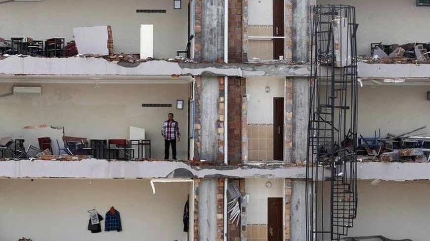 A man checks an apartment on a damaged building at the site of a blast in the town of Reyhanli in Hatay province, near the Turkish-Syrian border, May 13, 2013. Syria's information minister has blamed Turkey's government for deadly car bombings near the Syrian border and branded Prime Minister Tayyip Erdogan a "murderer", state-run Russian TV company RT reported on Monday. It said he repeated a denial of Syrian involvement in car bombings that killed 46 people on Saturday in the Turkish border town of Reyhan
