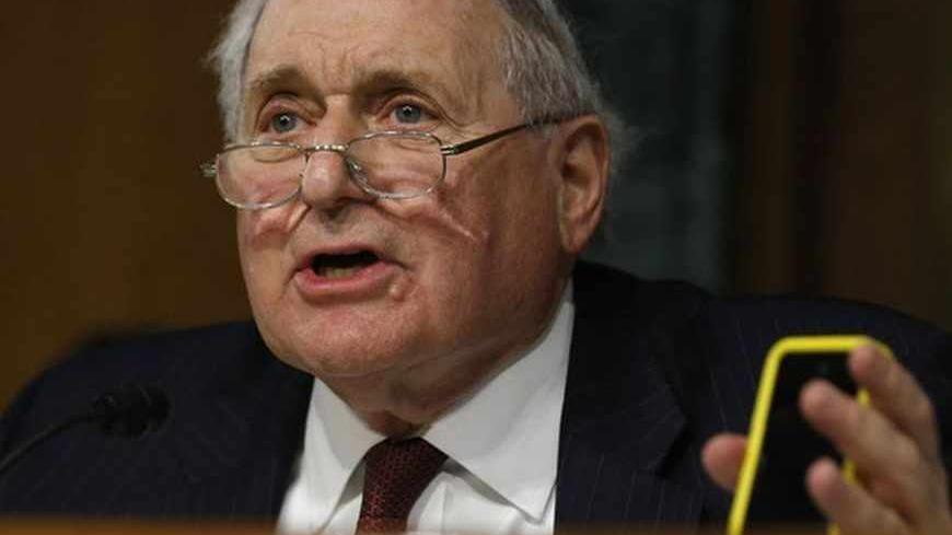 Senate homeland security and governmental affairs investigations subcommittee Chairman Carl Levin (D-MI) holds an iPhone as he speaks to Apple CEO Tim Cook during a hearing on offshore profit shifting and the U.S. tax code, on Capitol Hill in Washington, May 21, 2013. Apple Inc's chief executive officer defended the company's tax record at a Tuesday Senate hearing where lawmakers said the maker of iPads, iPods and Mac computers kept billions of dollars in profits in Irish subsidiaries to avoid U.S. taxes.  