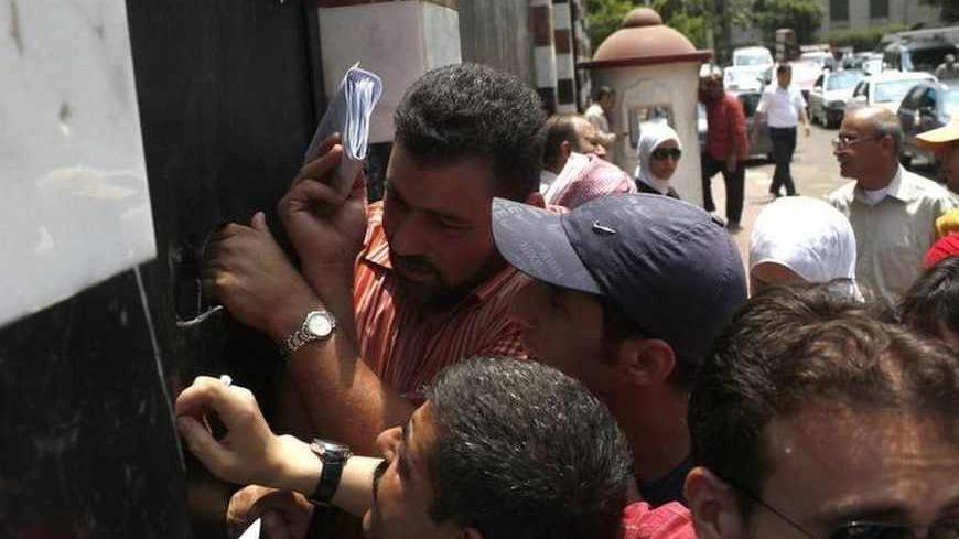 Syrians who are picking up their passports queue up in front of the Syrian Embassy in Cairo June 16, 2013. Egyptian President Mohamed Mursi said he had cut all diplomatic ties with Damascus on Saturday and called for a no-fly zone over Syria, pitching the most populous Arab state firmly against President Bashar al-Assad. REUTERS/Asmaa Waguih (EGYPT  - Tags: POLITICS) - RTX10PIR
