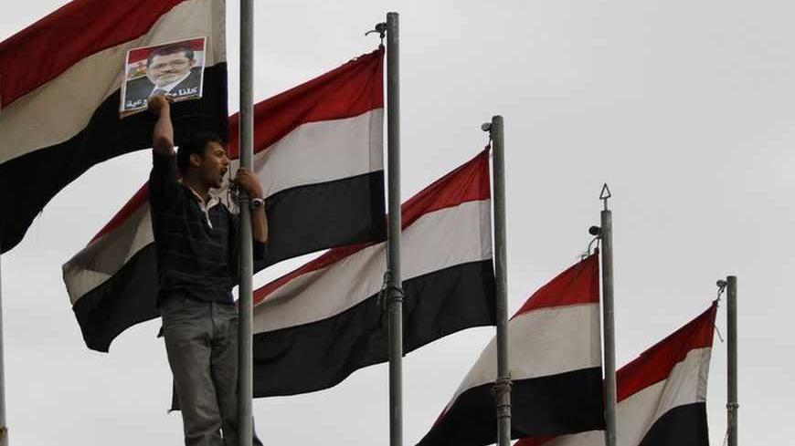 A protester holds a picture of deposed Egyptian President Mohamed Mursi during a pro-democracy demonstration in Sanaa July 8, 2013.       REUTERS/Mohammed al-Sayaghi (YEMEN - Tags: POLITICS CIVIL UNREST) - RTX11GUB