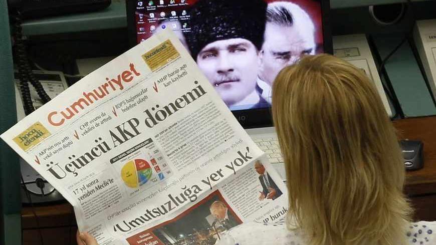 A trader reads a newspaper with the headline that reads "AK Party Term", during the morning session at the Istanbul Stock Exchange June 13, 2011. Turkish stocks rose on Monday after Prime Minister Tayyip Erdogan's AK Party won Sunday's parliamentary election to secure a third term of single-party rule. The AK Party won 50 percent of the vote to give Erdogan a third consecutive term. But the AK Party's parliamentary majority slipped, as it won 326 seats, down from 331 in the previous assembly. REUTERS/Murad
