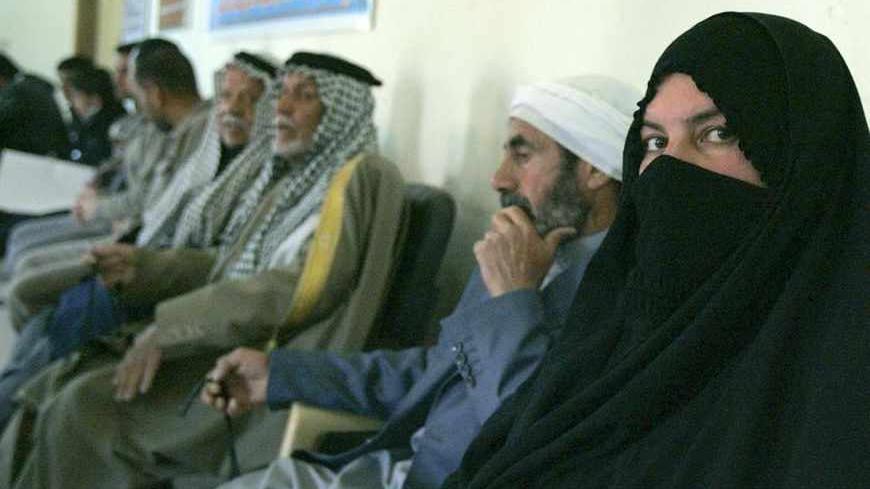 Relatives of missing people wait to fill application forms at a Human Rights office in Ramadi, 100 km (60 miles) west of Baghdad February 26, 2012. The Human Rights ministry in Iraq launched a campaign to test DNA and identify bodies. Around 300 suspected mass graves have been discovered around Iraq since Saddam Hussein was overthrown in 2003. Picture taken February 26, 2012.   REUTERS/Ali al-Mashhadani (IRAQ - Tags: POLITICS) - RTR2YKDR