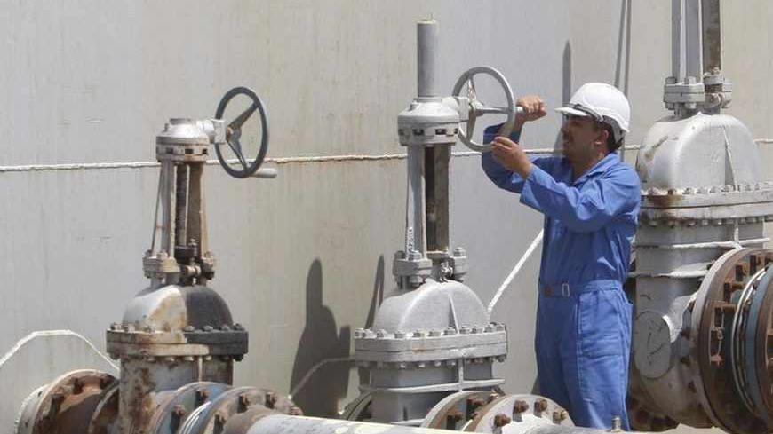 A worker adjusts a pipe at the Nassiriya oilfield in Nassiriya, 300km (185 miles) southeast of Baghdad, September 8, 2012. Production from Iraq's southern oilfields is at 2.5 million barrels per day as the country edges closer to becoming the world's biggest source of new supplies over the next few years, a senior Iraqi oil official said. Picture taken September 8, 2012. REUTERS/Atef Hassan (IRAQ - Tags: ENERGY BUSINESS) - RTR37U0M