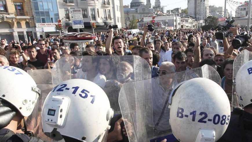 Riot police guard the entrance of Gezi Park as anti-government protesters shout slogans at Taksim square in central Istanbul July 20, 2013.  REUTERS/Osman Orsal (TURKEY - Tags: CIVIL UNREST POLITICS) - RTX11T4H