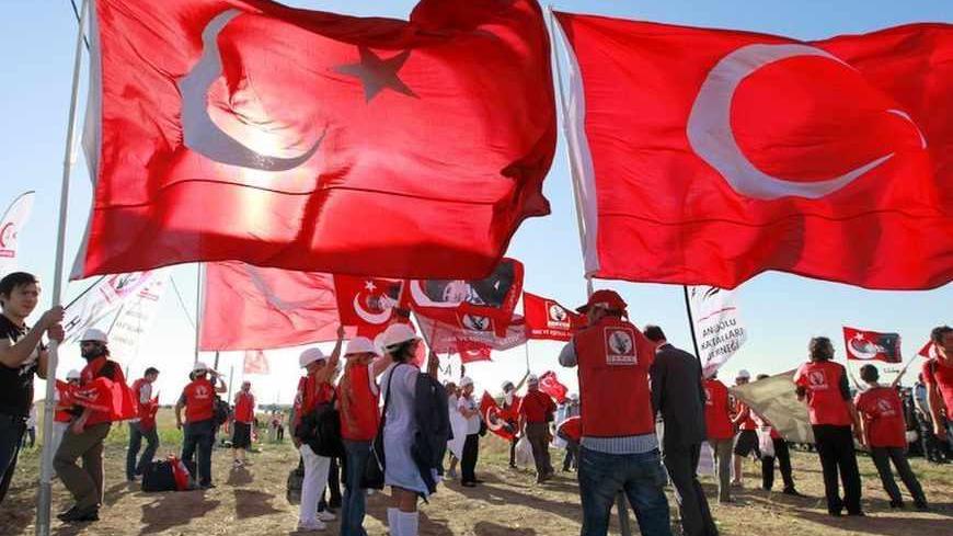 Protesters hold Turkish flags as they gather near a courthouse in Silivri, where a hearing on people charged with attempting to overthrow Prime Minister Tayyip Erdogan's Islamist-rooted government is due to take place, August 5, 2013.  A Turkish court sentenced retired military chief of staff General Ilker Basbug to life in jail on Monday for his role in the "Ergenekon" conspiracy to overthrow the government of Prime Minister Tayyip Erdogan. The court judges, announcing verdicts on the 275 defendants in the