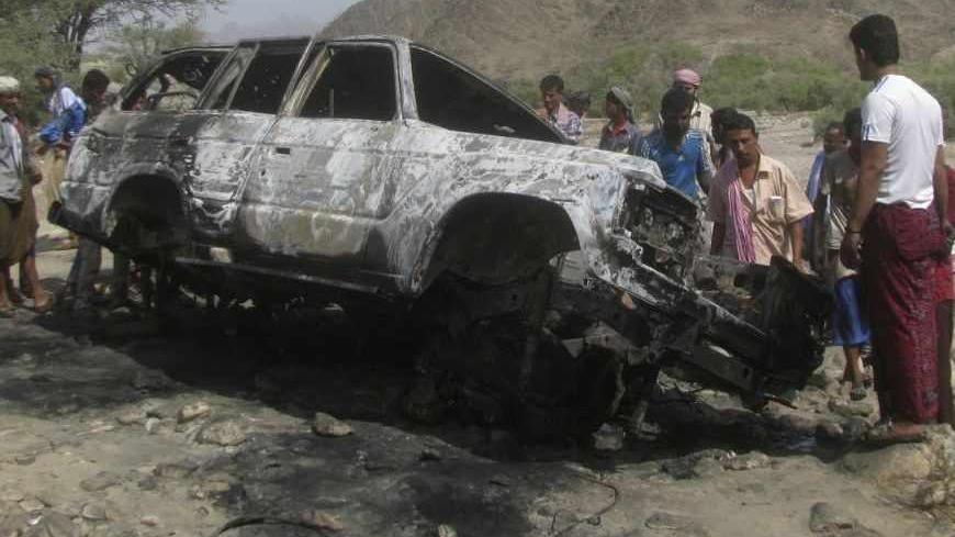 People gather at the site of a drone strike on the road between Yafe and Radfan districts of the southern Yemeni province of Lahj August 11, 2013. Local officials and residents in Yemen's southern Lahj Province said a drone destroyed a vehicle travelling on a mountain road late on Saturday evening killing its two occupants and bringing to 15 the death toll from four strikes in three days. REUTERS/Stringer (YEMEN - Tags: POLITICS CIVIL UNREST) - RTX12H45