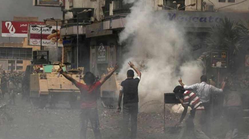 Supporters of ousted Egyptian President Mohamed Mursi throw stones at riot police and army personnel during clashes near Rabaa Adawiya square in Cairo August 14, 2013. Egypt is in turmoil after security forces moved in to clear the protest camps of thousands of supporters of deposed Islamist president Mohamed Mursi on Wednesday, and violence spread around the country. Protesters clashed with police and troops who used bulldozers, teargas and live ammunition to clear two Cairo sit-ins. Egypt's health ministr