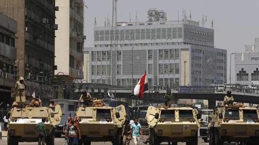 Soldiers stand guard on an armoured personnel carrier positioned outside Ramses Square, near al-Fath mosque in Cairo August 17, 2013. Egyptian authorities rounded up more than 1,000 Islamists as the Muslim Brotherhood leadership defiantly called a week of nationwide protests starting on Saturday after a day of carnage. After Friday's bloodshed in which more than 100 people died in clashes that pushed Egypt ever closer to anarchy, tensions were high with supporters of ousted Islamist President Mohamed Mursi 