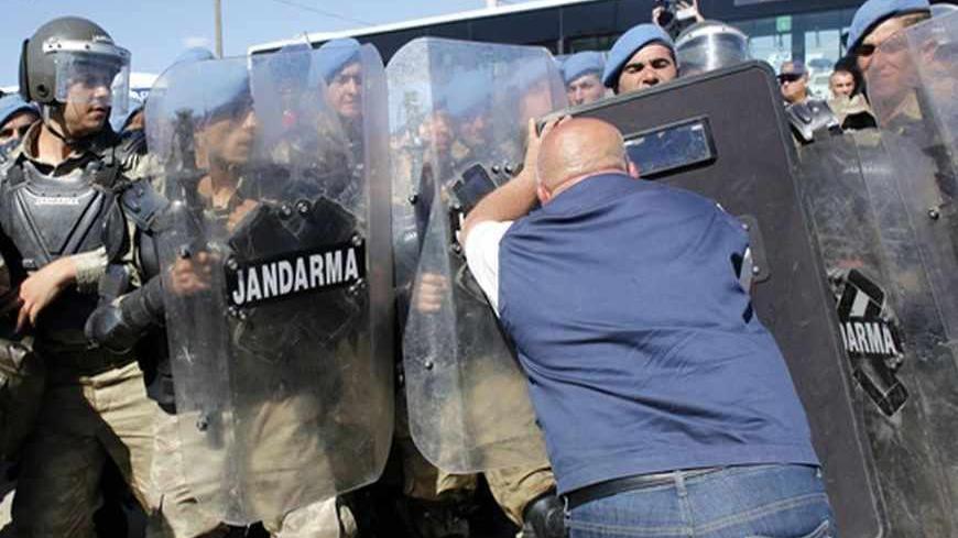 A protester pushes into Turkish soldiers during clashes near Silivri, where a hearing on people charged with attempting to overthrow Prime Minister Tayyip Erdogan's Islamist-rooted government is due to take place August 5, 2013. A Turkish court on Monday sentenced a former military commander to life in prison and dozens of others including opposition members of parliament to long terms for plotting against the government, in a case that has exposed deep divisions in the country. Retired military chief of st