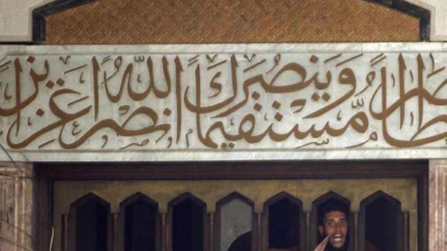 A protester who supports ousted Egyptian President Mohamed Mursi shouts through an opening at the top of an entrance to the al-Fath mosque on Ramses Square in Cairo August 17, 2013. Egyptian authorities rounded up more than 1,000 Islamists as the Muslim Brotherhood leadership defiantly called a week of nationwide protests starting on Saturday after a day of carnage. REUTERS/Amr Abdallah Dalsh (EGYPT - Tags: POLITICS CIVIL UNREST RELIGION TPX IMAGES OF THE DAY) - RTX12OHE