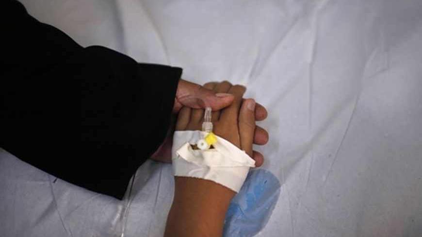Cancer patient and blind Palestinian girl Aseel al-Haj Ahmed, 9, holds her mother's hand as she receives a regular treatment in a hospital in Gaza City April 29, 2013. Al-Haj Ahmed was afflicted with cancer when she was four months old, when doctors had to remove both her eyes and replace them with ocular prostheses as a result of a malignant tumour that struck her spinal cord. The schoolgirl is looked after by her unemployed father whose impoverished family includes his wife and four other children. Al-Haj