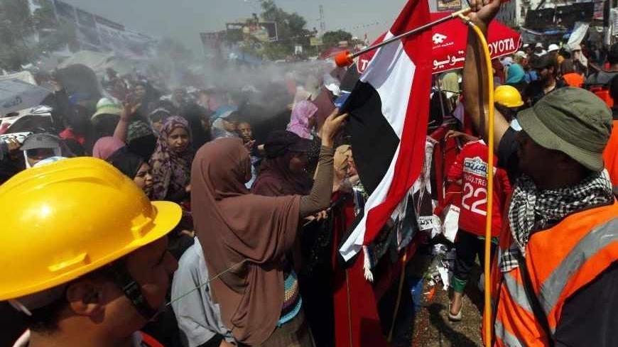 A man sprays water on supporters of deposed Egyptian President Mohamed Mursi, as they shout slogans during a protest at the Rabaa Adawiya square where they are camping, in Cairo August 2, 2013. Tens of thousands of supporters of Mursi marched through Cairo on Friday, demanding Mursi's reinstatement amidst a looming threat that Egyptian authorities will clear out two pro-Mursi sit-ins with force.      REUTERS/Mohamed Abd El Ghany (EGYPT - Tags: POLITICS CIVIL UNREST) - RTX128JA