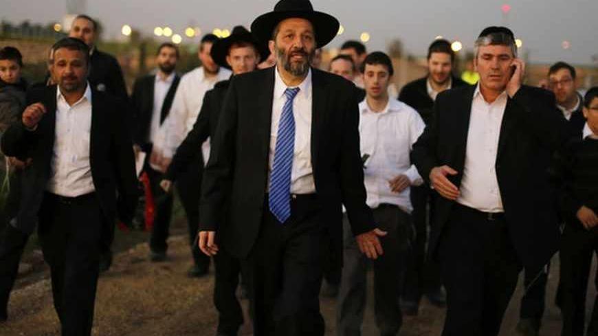 Aryeh Deri (C), leader of the ultra-Orthodox Shas party, attends an annual pilgrimage to the gravesite of Rabbi Yisrael Abuhatzeira, a Moroccan-born sage and kabbalist also known as the Baba Sali, in the southern town of Netivot January 14, 2013.  Powerful political players for years, Israel's ultra-Orthodox parties must now reckon with a new force ushered in by voters bent on stripping them of perks they have relied on for decades. Picture taken January 14, 2013. REUTERS/Amir Cohen (ISRAEL - Tags: POLITICS