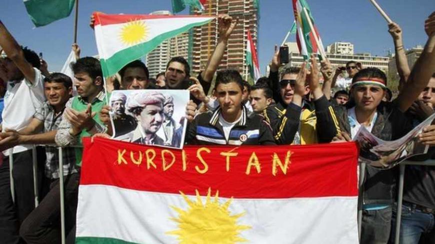 Men hold Kurdish flags and a poster of Kurdistan leader Masoud Barazani during a Nowruz celebration organized by Kurdish groups at the seaside town of Rawshe in Beirut, March 21, 2013. REUTERS/Sharif Karim (LEBANON - Tags: RELIGION POLITICS) - RTR3FA2H