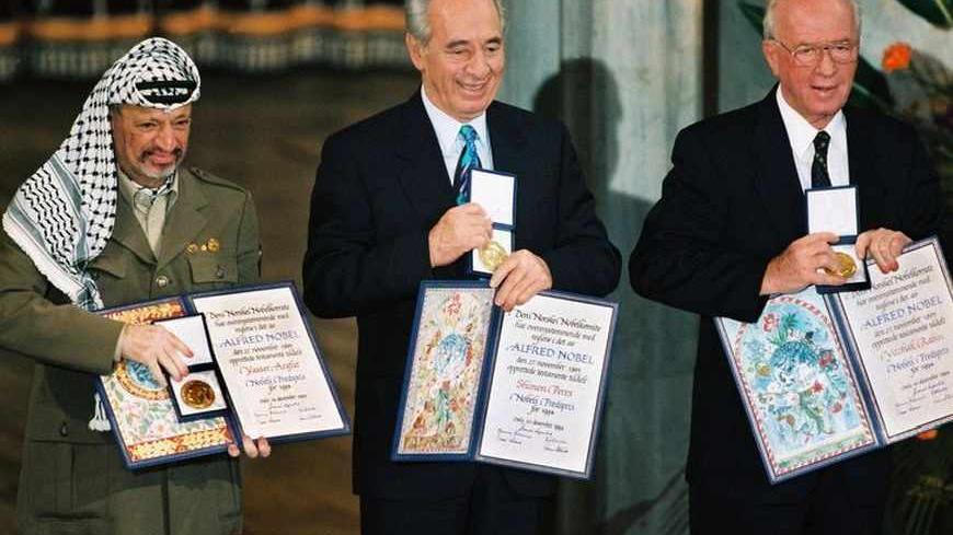 File photograph of Palestinian President Arafat, Israel's Perez and Israeli Prime Minister Rabin showing their Nobel Peace Prize in Oslo. Palestinian President Yasser Arafat was in a coma and in critical condition in the intensive care unit at a French military hospital after his health suddenly deteriorated, aides said November 4, 2004. Palestinian President Yasser Arafat, (L) Israel's Shimon Perez (C) and Israeli Prime Minister Yitzhak Rabin show their Nobel Peace Prize in Oslo in this December 10, 1994