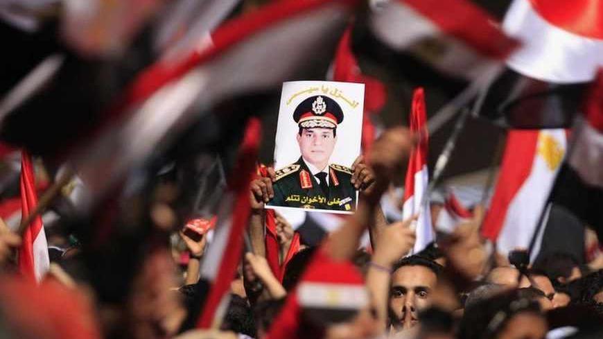 Protesters, who are against Egyptian President Mohamed Mursi, hold a poster featuring the head of Egypt's armed forces General Abdel Fattah al-Sisi in Tahrir Square in Cairo July 3, 2013. Egypt's armed forces overthrew elected Islamist President Mohamed Mursi on Wednesday and announced a political transition with the support of a wide range of political, religious and youth leaders. A statement published in Mursi's name on his official Facebook page after al-Sisi's speech said the measures announced amounte