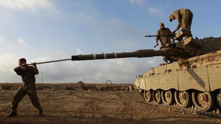 An Israeli soldier cleans the barrel of a tank near the border with Syria in the Israeli-occupied Golan Heights July 17, 2013. Syria's civil war has brought an end to decades of calm on the Golan Heights, a strip of land which Israel captured in the 1967 Middle East war. Battles between rebels fighting against President Bashar al-Assad's forces in Syrian villages nearby are being watched intensely by Israel's military. REUTERS/Baz Ratner (POLITICS MILITARY TPX IMAGES OF THE DAY) - RTX11P94