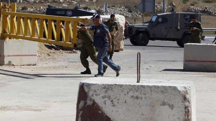 Israeli soldiers and a security personnel open the gate of a check-point in the West Bank city of Hebron July 21, 2013. The Israeli government reopened a main road at the southern West Bank district of Hebron after a 12-year closure, a Palestinian Authority liaison official said. REUTERS/Mussa Qawasma (WEST BANK - Tags: CIVIL UNREST TRANSPORT POLITICS MILITARY) - RTX11U38
