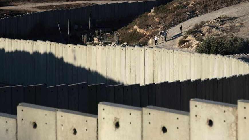 A section of the controversial Israeli barrier snakes around Shuafat refugee camp (R) in the West Bank near Jerusalem July 27, 2013. Israeli and Palestinian officials put forward clashing formats for peace talks due to resume in Washington on Monday for the first time in nearly three years after intense U.S. mediation. It is unclear how the United States hopes to bridge the core issues in the dispute, including borders, the future of Jewish settlements on the West Bank, the fate of Palestinian refugees and