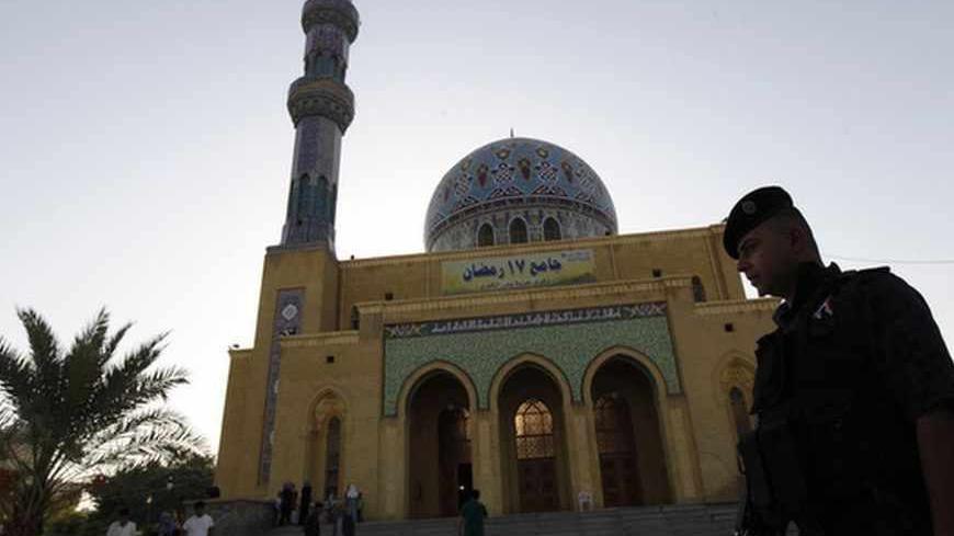 An Iraqi policeman stands guard outside a Sunni mosque during Eid al-Fitr prayers in Baghdad, August 8, 2013. The Eid al-Fitr festival marks the end of the Muslim holy fasting month of Ramadan.  REUTERS/Thaier al-Sudani (IRAQ - Tags: RELIGION) - RTX12DJC