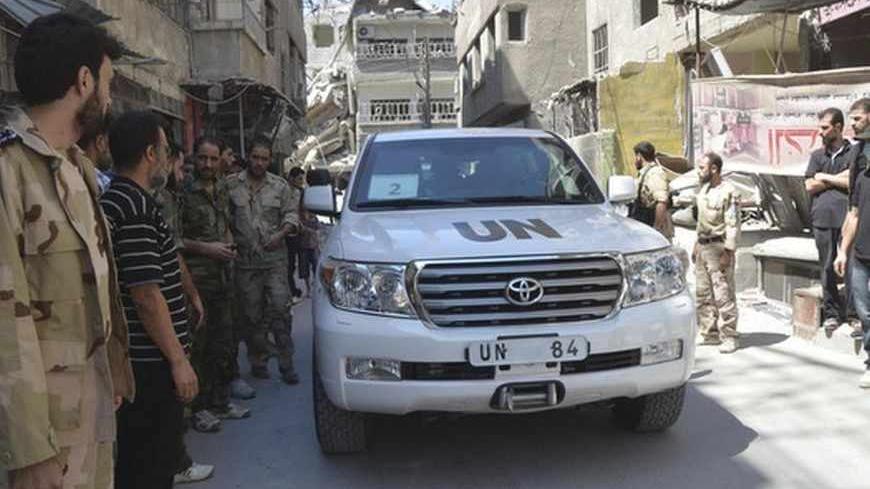 Free Syrian Army fighters and residents gather around a convoy of U.N. vehicles carrying a team of United Nations chemical weapons experts at one of the sites of an alleged chemical weapons attack in Damascus' suburbs of Zamalka August 28, 2013. U.N. chemical weapons experts investigating the apparent gas attack that killed hundreds of civilians in rebel-held suburbs of Damascus made a second trip across the front line to take samples. REUTERS/Bassam Khabieh    (SYRIA -  Tags: - Tags: POLITICS CIVIL UNREST 