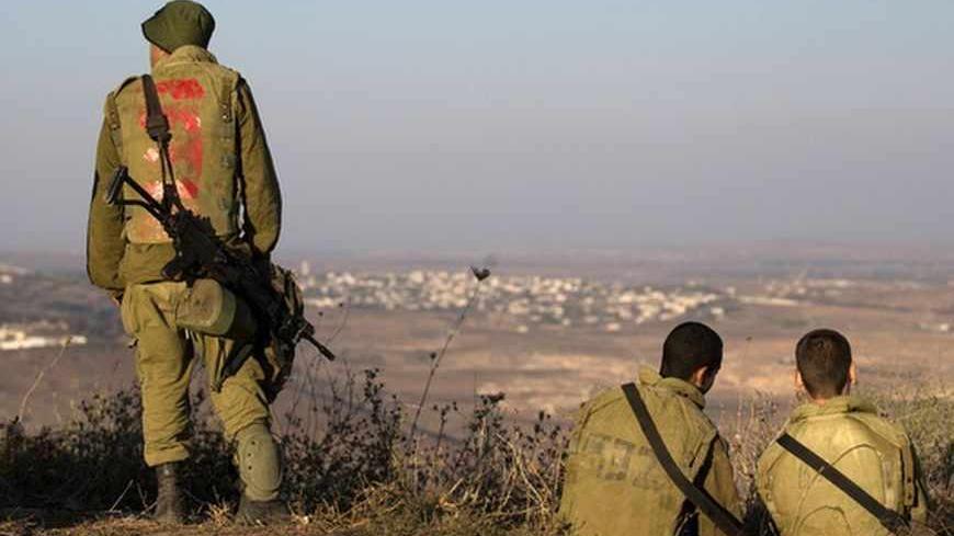 Israeli soldiers look across the border to Syria in the Israeli-occupied Golan Heights August 30, 2013. Israel ordered a small-scale mobilisation of reservists on Wednesday and strengthened its missile defences as precautions against possible Syrian attack should Western powers carry out threatened strikes on Syria. REUTERS/Ronen Zvulun (MILITARY POLITICS) - RTX131QH