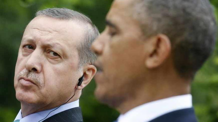 Turkish Prime Minister Recep Tayyip Erdogan (L) listens to U.S. President Barack Obama during a joint news conference in the White House Rose Garden in Washington, May 16, 2013. REUTERS/Kevin Lamarque (UNITED STATES - Tags: POLITICS) - RTXZPB1