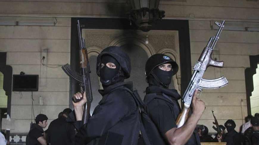 Policemen stand guard inside a room of the al-Fath mosque when supporters of deposed Egyptian President Mohamed Mursi exchanged gunfire with security forces inside the mosque in Cairo August 17, 2013.The gunmen opened fire on security forces from a second floor window in the Fath mosque, where hundreds of Mursi supporters have been taking refuge since protests turned violent on Friday. REUTERS/Muhammad Hamed (EGYPT - Tags: POLITICS CIVIL UNREST RELIGION) - RTX12OKU